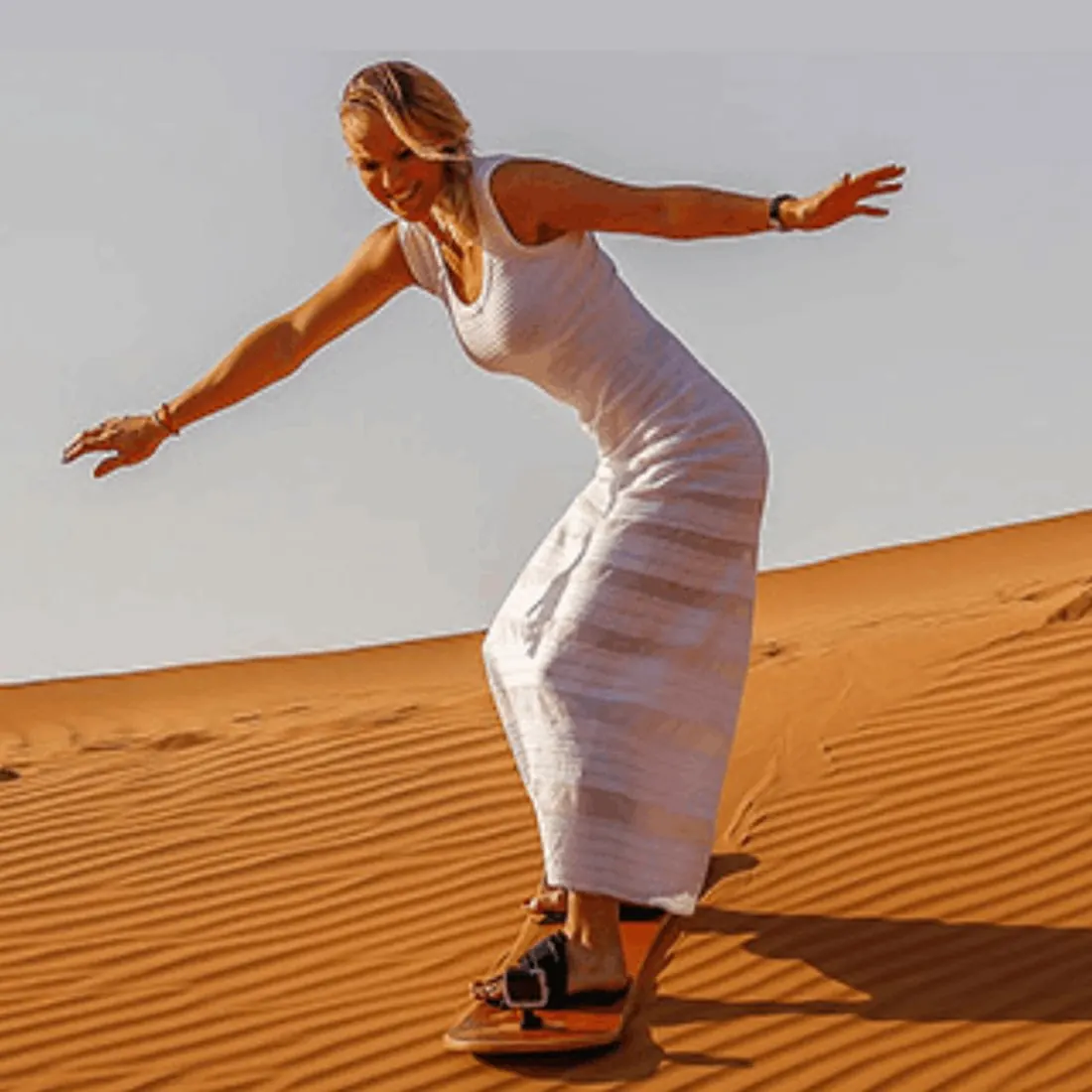 Ragazza che scende da una duna in sandboard a Erg Chebbi