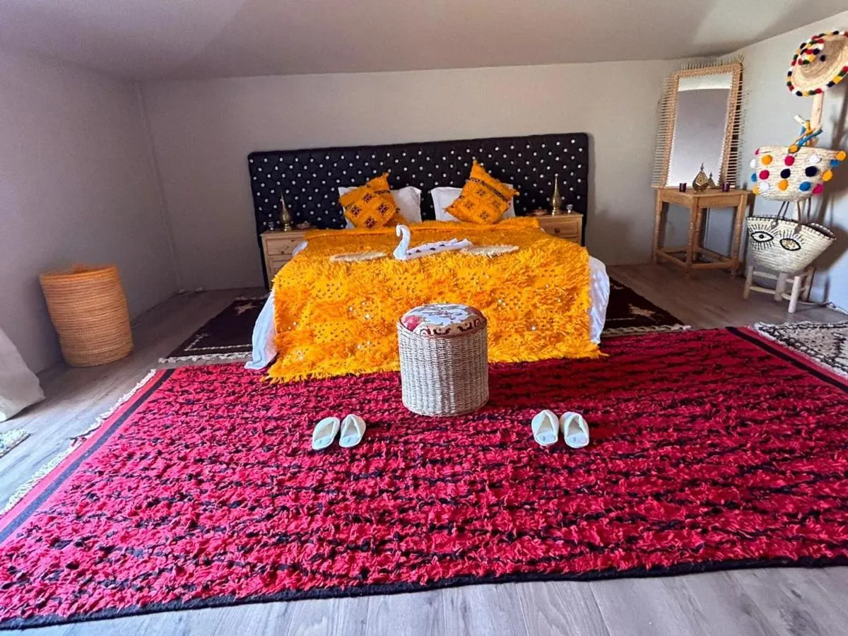Letto king size con coperta arancione in una tenda VIP
