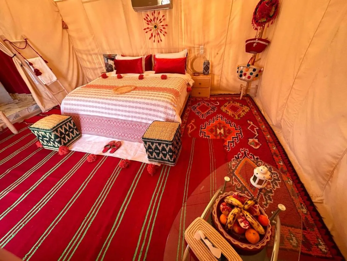 Tenda VIP di lusso con letto rosso e tappeto berbero a righe